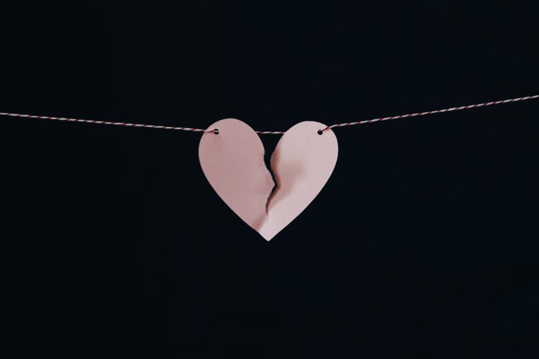 pink broken paper heart on a chain engagement photo