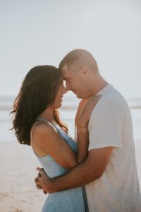 romantic engagement photo of engaged couple posed forehead to forehead on the beach in Venice California